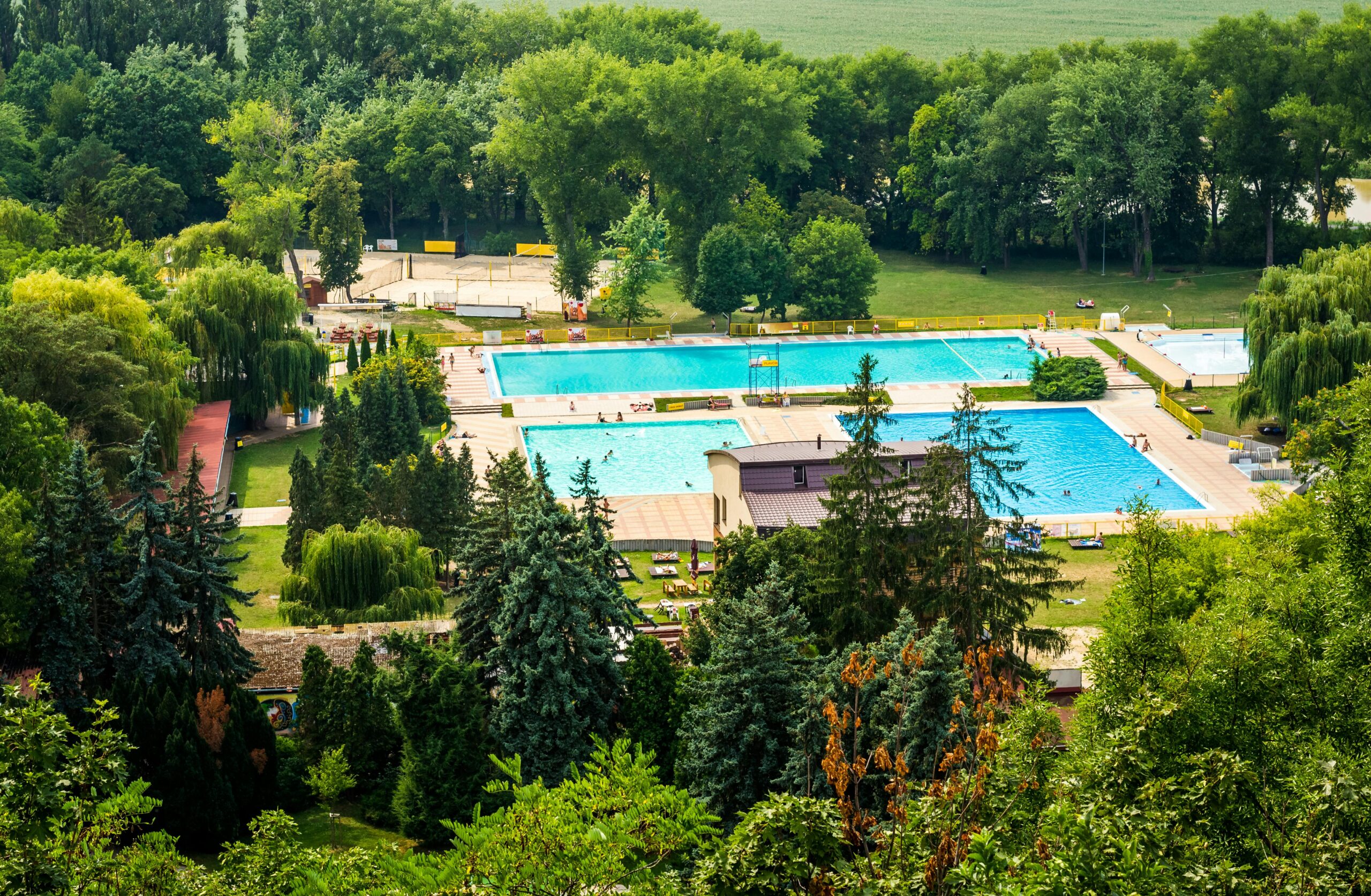 Stunning aerial view of swimming pools surrounded by lush greenery in Nitra, Slovakia, during summer.